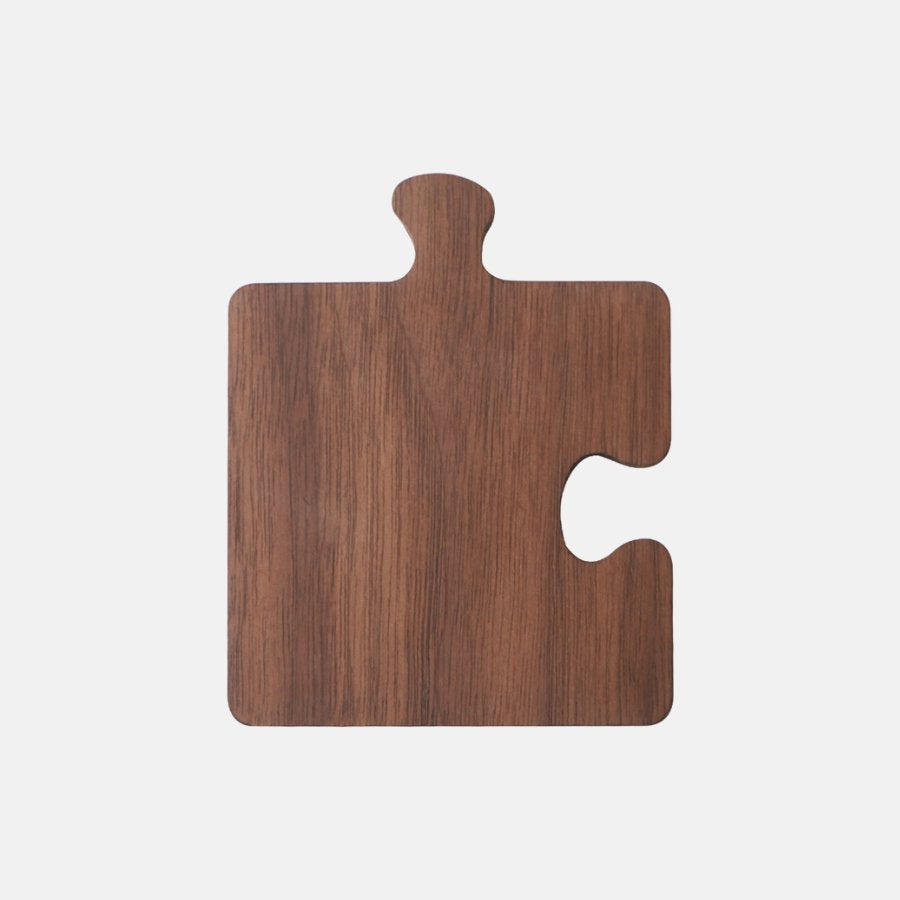 A dark stained wood puzzle piece coaster set of four.