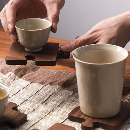 A dark stained wood puzzle piece coaster set of four.