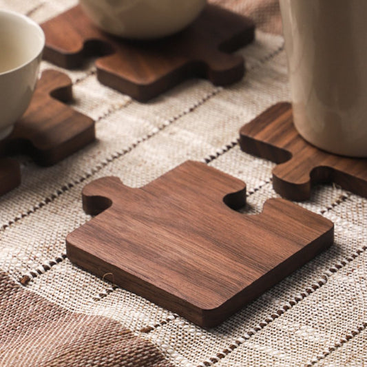 A dark stained wood puzzle piece coaster set of four.