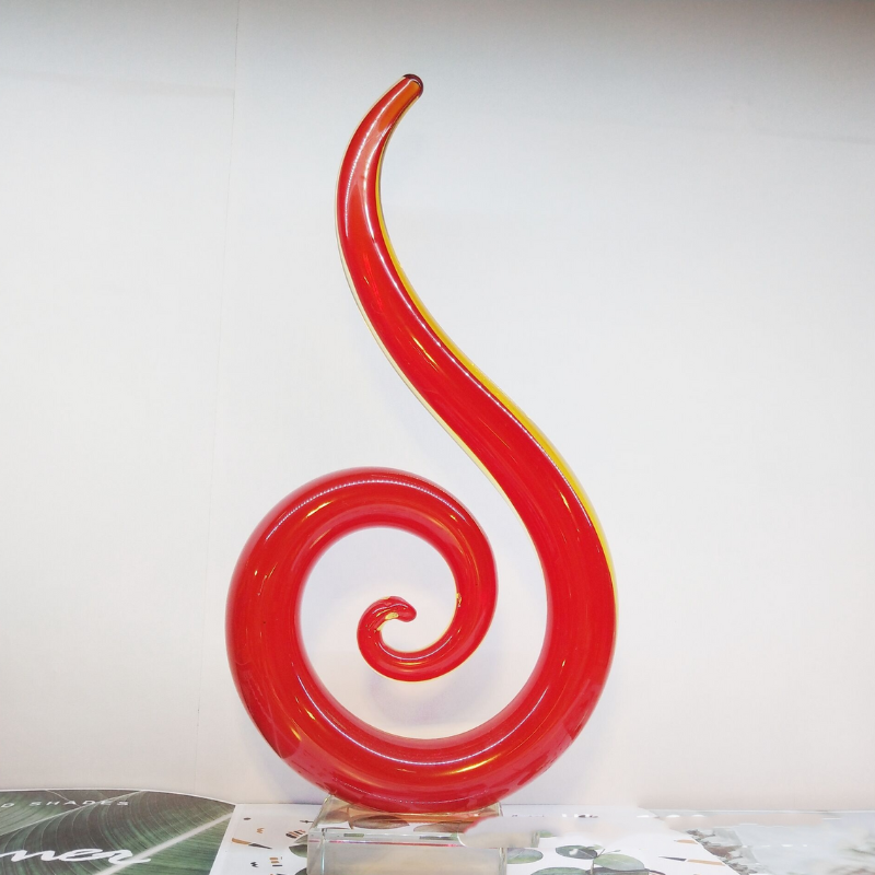 A red hand blown glass teardrop shaped ornament. A modern piece for mantel or shelf decor.