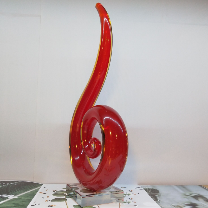 A red hand blown glass teardrop shaped ornament. A modern piece for mantel or shelf decor.