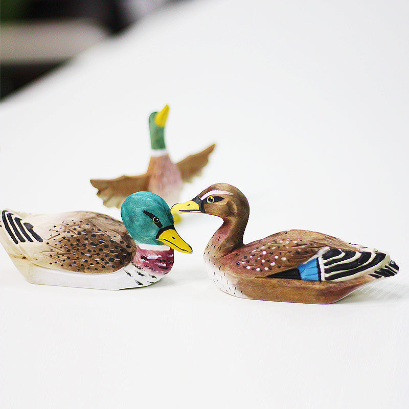 Three small hand carved wood ducks are imaged. It is a mallard, painted with detail. A unique gift for duck lovers and hunters alike.