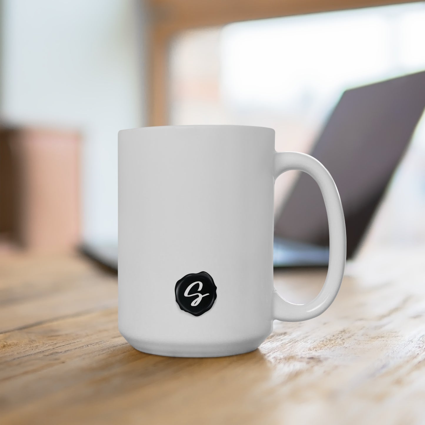 Sydney's Collection black wax seal logo is featured on a coffee mug.