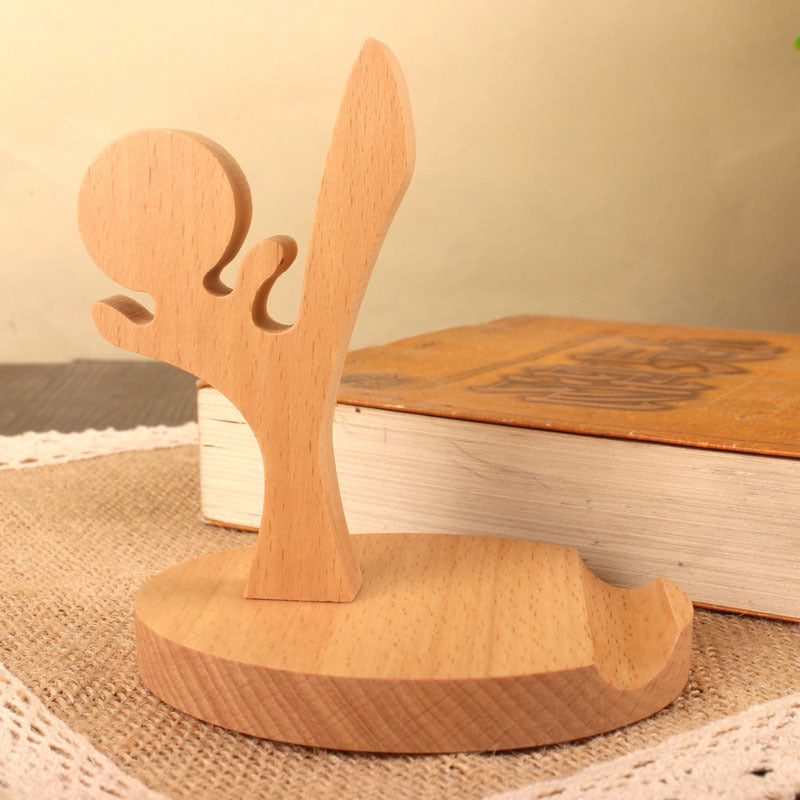 Wood animal shaped phone stand in tai chi pose, handmade from natural wood, stylish and functional accessory.