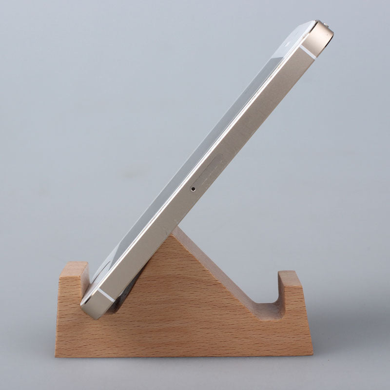 Wood animal shaped phone stand holding a smartphone at an angle on a light background.