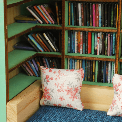 Miniature Anxiety Book Room with tiny bookshelves, plush pillows, and cozy reading nook details.