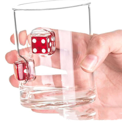 Hand holding a clear glass cup with red casino dice embedded, perfect for whiskey lovers.