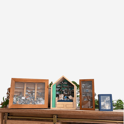 Miniature bookshelves displayed on a wooden shelf, part of the Four Piece Anxiety Bookshelf Collection.